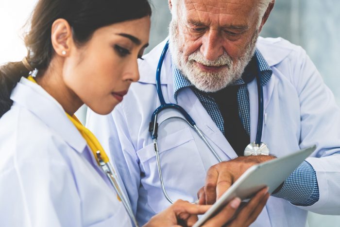 Doctors Working With Tablet Computer At Hospital.