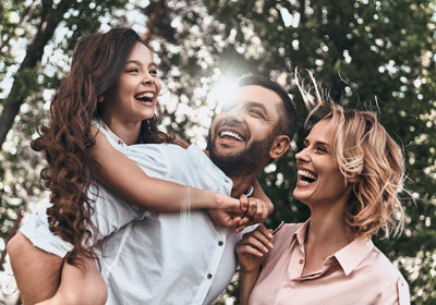 goodencenter-mental-health-treatment-photo-of-Happy-young-family-of-three-smiling-while-spending-free-time-outdoors