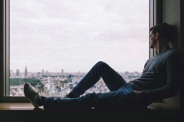 goodencenter-The-LGBTQ+-Community-and-Substance-Use--photo-of-a-lonely-man-sitting-near-the-window