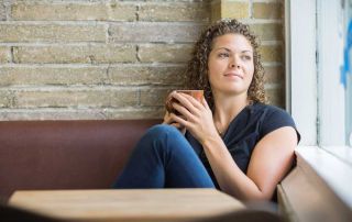 goodencenter-Mindfulness-for-OCD-Tips-and-Skills-for-Living-photo-of-a-thoughtful-woman-holding-coffee-mug