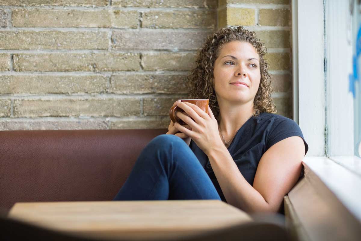 goodencenter-Mindfulness-for-OCD-Tips-and-Skills-for-Living-photo-of-a-thoughtful-woman-holding-coffee-mug