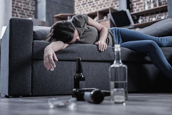 goodencenter alcohols effect on the body photo of a Sleepy drunk young woman lying on the sofa