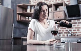 goodencenter alcohols effect on the body photo of a woman holding a bottle while pouring wine