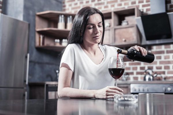 goodencenter alcohols effect on the body photo of a woman holding a bottle while pouring wine