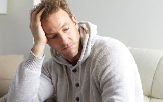 goodencenter 5 Signs of Depression Relapse and How to Avoid Them photo of a depressed man sitting on a couch