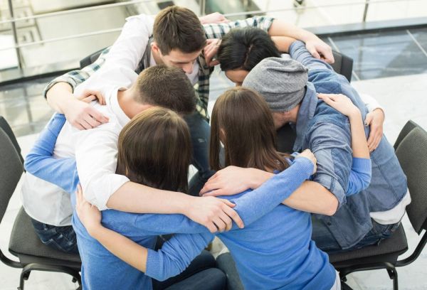 goodencenter Meditation and Mental Health photo of group of people are sitting embracing in circle 