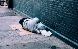 gooden center The Connection Between Homelessness and Addiction photo of a homeless man lying in the street