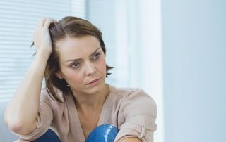 goodencenter How to Identify Signs of Mental Illness in a Loved One photo of a depressed woman looking away at home