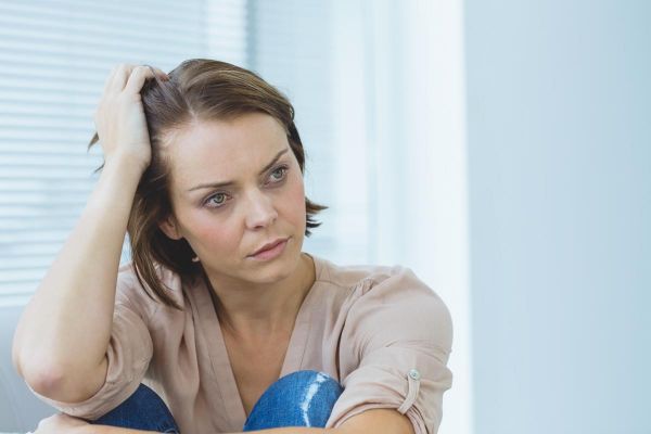 goodencenter How to Identify Signs of Mental Illness in a Loved One photo of a depressed woman looking away at home