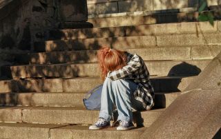 photo of a lonely woman sitting in the stairs