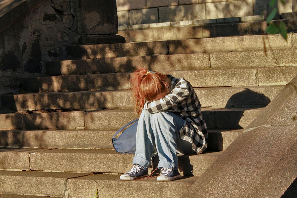 photo of a lonely woman sitting in the stairs